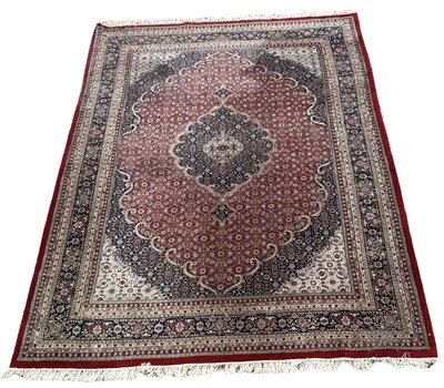 Lot 126 - A large Persian red ground floral decorated...