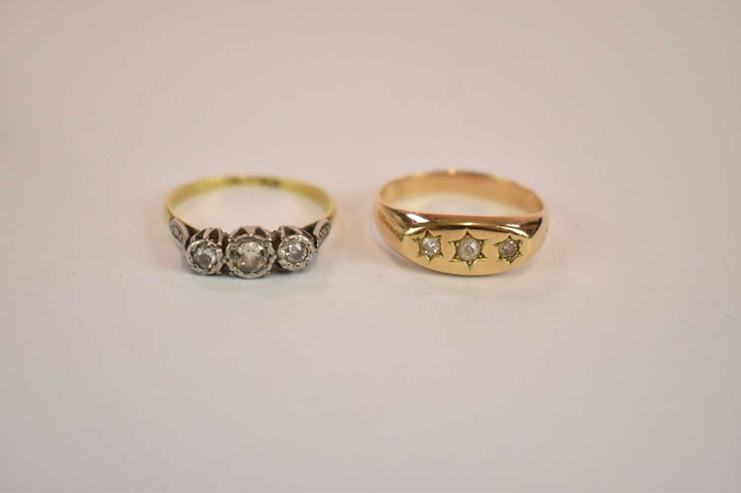 Lot 1153 - A yellow metal three stone diamond ring,