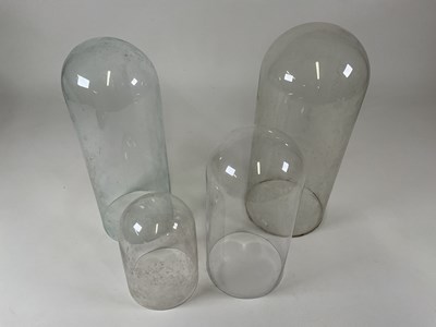 Lot 214 - Four glass domes, largest height 52cm.