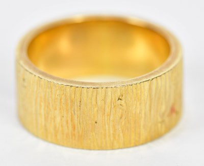 Lot 83 - An 18ct yellow gold textured wedding band,...