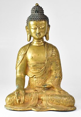 Lot 411 - A gilded bronze figure of a seated Buddha,...