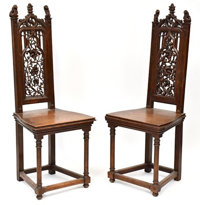 Lot 99 - A pair of carved oak hall chairs with pierced...