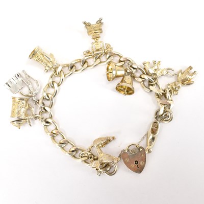 Lot 755 - A hallmarked silver charm bracelet with nine...