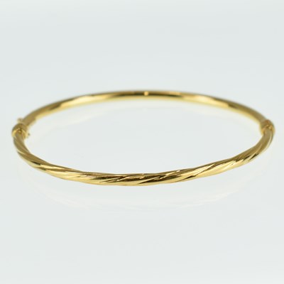 Lot 746 - An 18ct yellow gold hinged bracelet with snap...