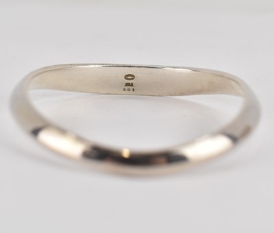 Lot 757 - GEORG JENSEN; a sterling silver curve bangle,...