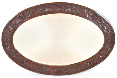 Lot 108 - An oval oak bevel edged mirror, the frame...