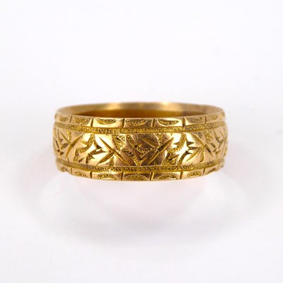 Lot 716 - An 18ct gold band ring with textured pattern,...