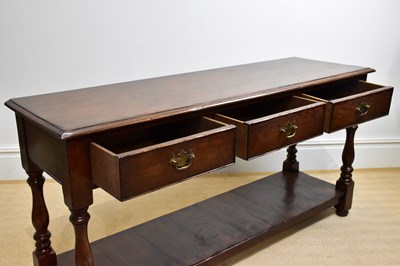 Lot 47 - A 20th century three drawer oak dresser base,...
