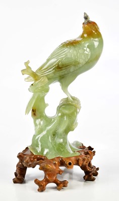 Lot 1173 - A Chinese carved jade figure of a bird perched...