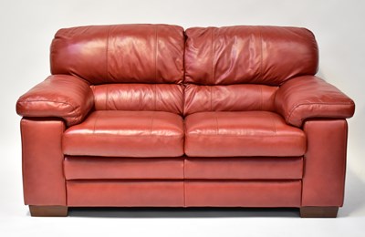Lot 10 - A modern red leather two-seater sofa with...