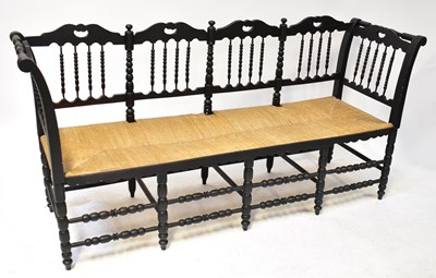 Lot 85 - A black painted rush-seated four-seat bench,...
