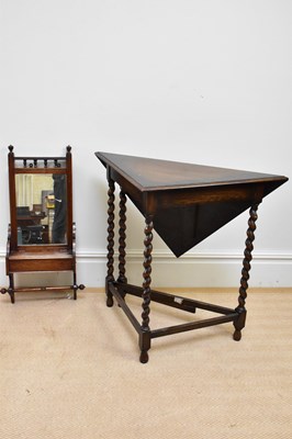 Lot 109 - A 1920s oak drop-leaf corner table on barley...