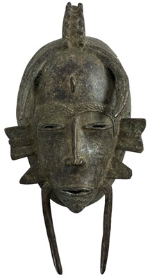 Lot 1222 - A bronze Senufo mask, height 30cm, width 15cm.