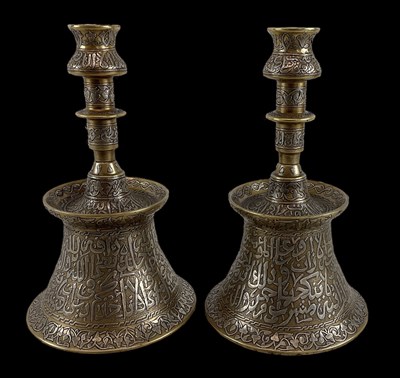 Lot 1044 - A pair of Islamic brass and silver inlaid...