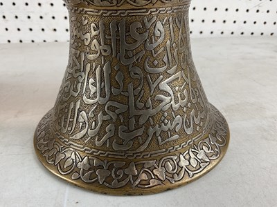 Lot 1044 - A pair of Islamic brass and silver inlaid...