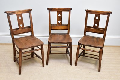 Lot 114 - Three elm seated chapel chairs (3).