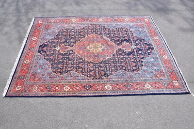 Lot 425 - A red ground wool carpet with central...