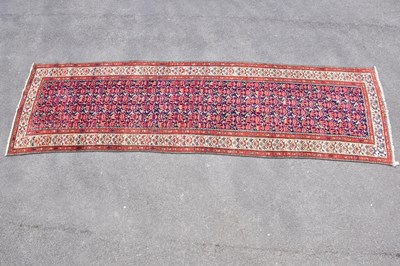 Lot 436 - A red ground wool runner with geometric...