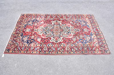 Lot 454 - A red ground wool carpet with geometric...