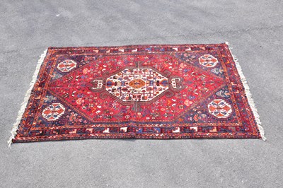 Lot 442 - A red ground wool rug with central geometric...