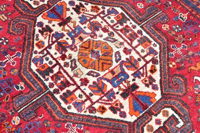 Lot 442 - A red ground wool rug with central geometric...
