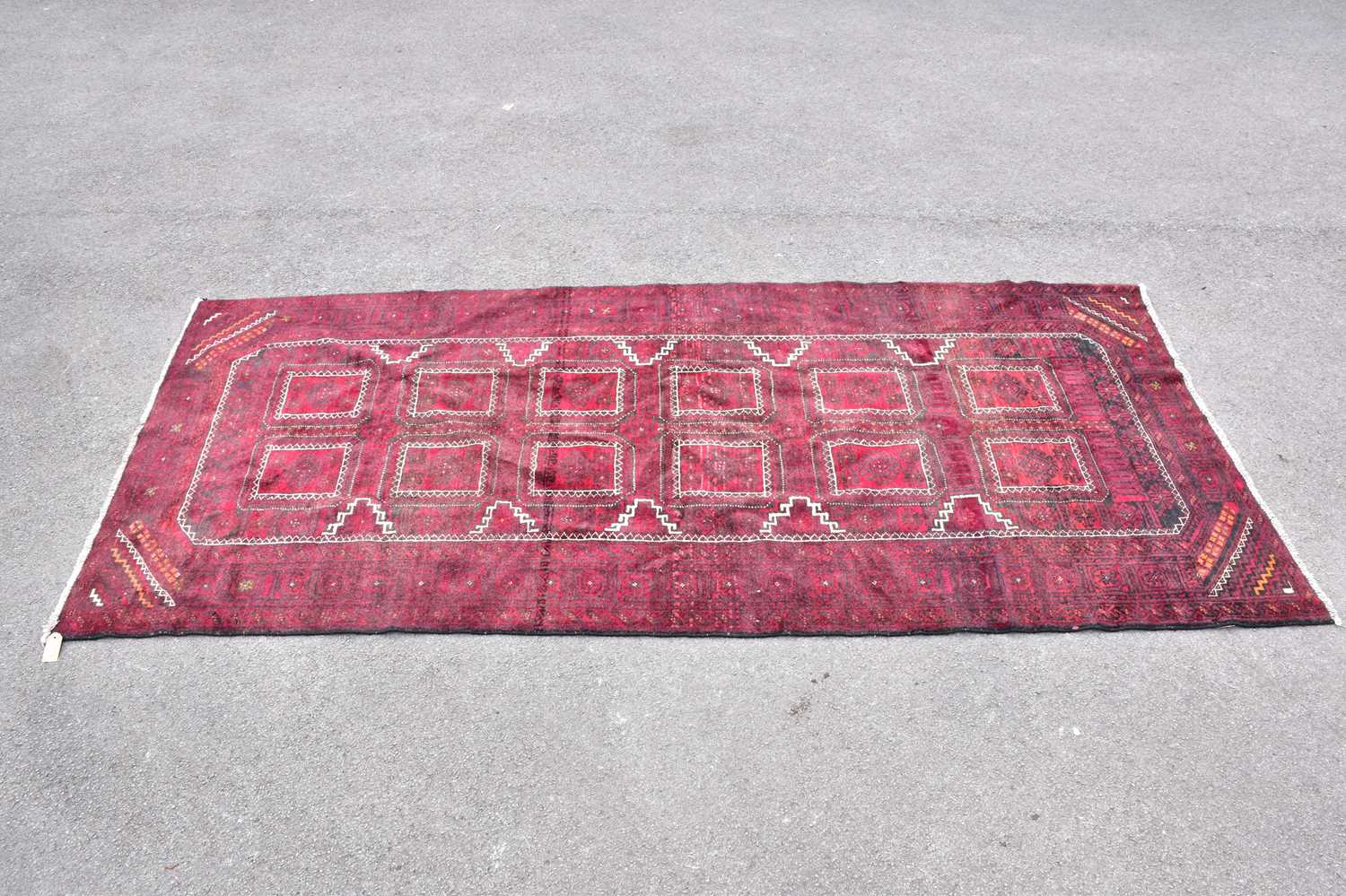 Lot 443 - A red ground wool carpet with geometric...