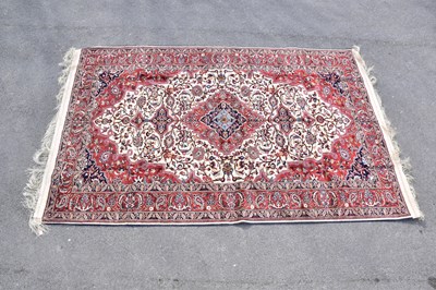 Lot 438 - A red ground silk machined carpet with floral...