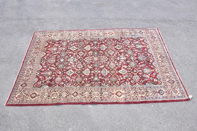 Lot 441 - A red ground wool carpet with floral geometric...