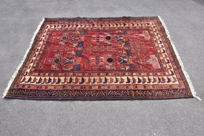 Lot 431 - A red ground wool carpet with geometric...