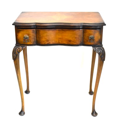 Lot 70 - A reproduction walnut veneered lowboy with...