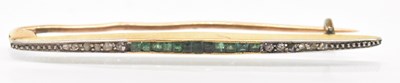 Lot 1263 - A yellow metal emerald and diamond set bar...