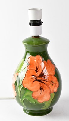 Lot 115 - MOORCROFT; a 'Hibiscus' pattern lamp base on...