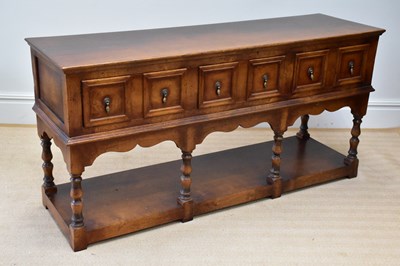 Lot 232 - A reproduction oak dresser base with three...