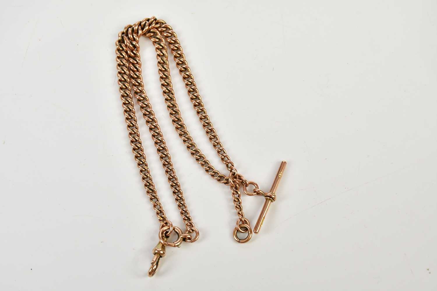 Lot 2326 - A 9ct rose gold Albert chain with T-bar, each...