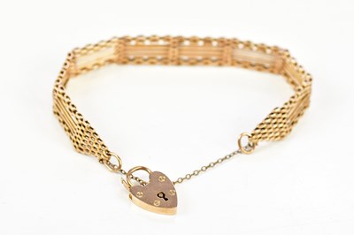 Lot 2488 - A 9ct gold curb link bracelet with padlock...