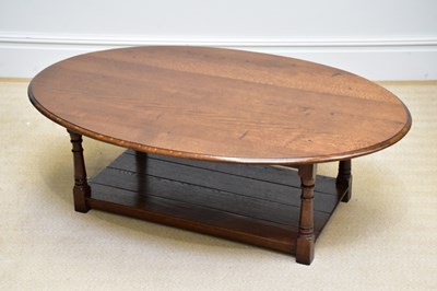 Lot 253 - A reproduction oak oval topped coffee table...