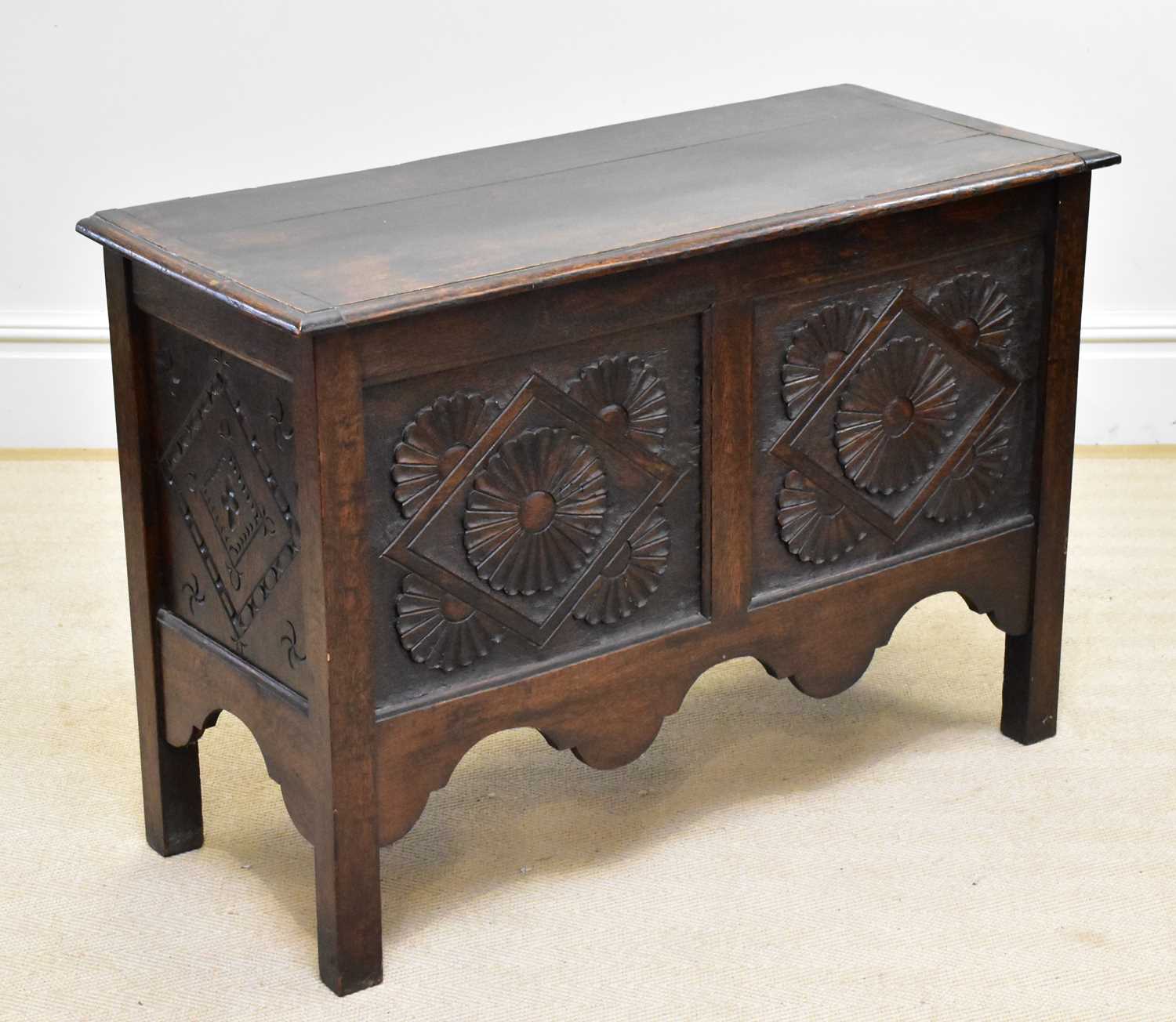 Lot 11 - A carved oak coffer with lozenge and floral...