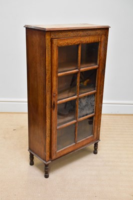 Lot 38 - A 1930s oak display cabinet, with glazed door...