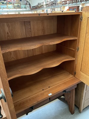 Lot 15 - A modern oak cupboard on stand, with two short...