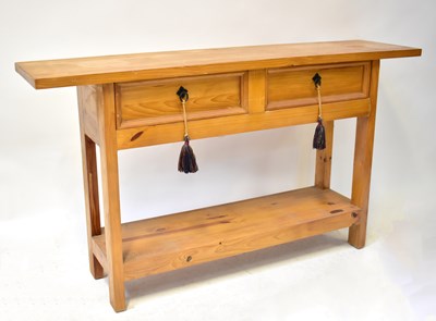 Lot 56 - A pine hall table with a pair of drawers above...