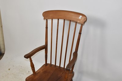 Lot 1486 - An elm seated spindle back elbow chair on...