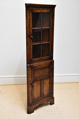 Lot 243 - A reproduction oak freestanding corner...