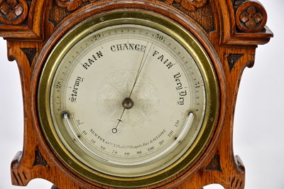 Lot 419 - A late Victorian carved oak barometer, the...