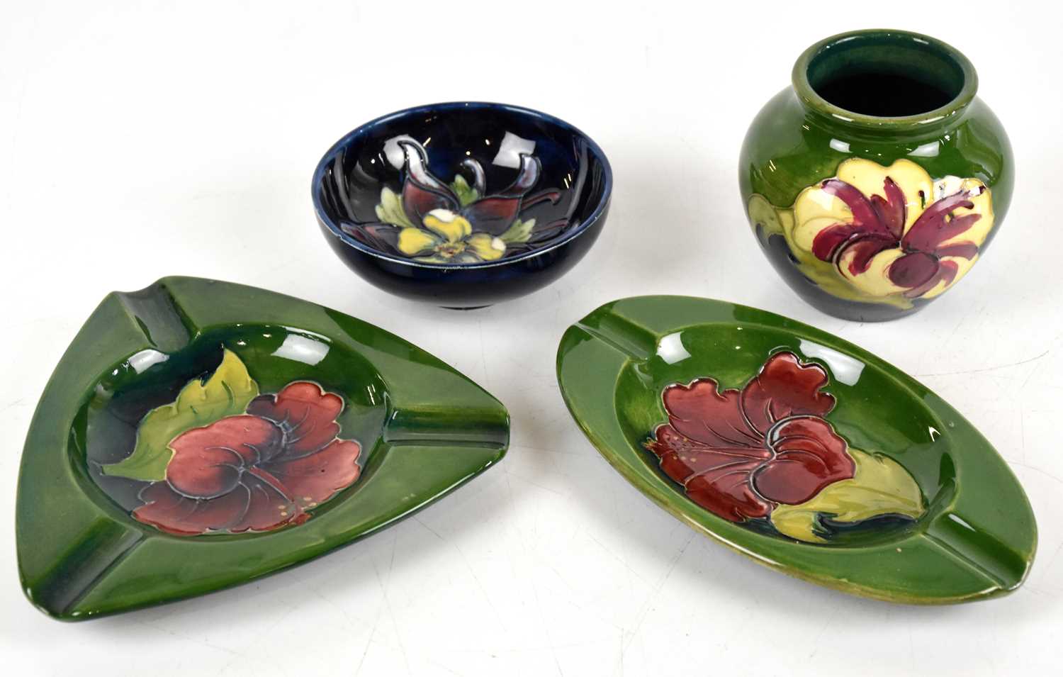 Lot 853 - MOORCROFT; four pieces comprising a footed...