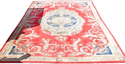 Lot 84 - An Aubusson-style wool rug, red ground with...
