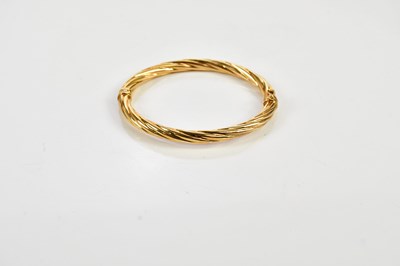 Lot 2492 - A yellow metal hinged snap bangle, stamped 375,...