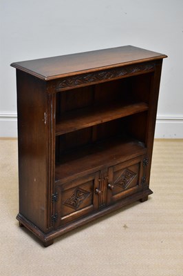 Lot 1080 - A reproduction oak bookcase with two cupboard...