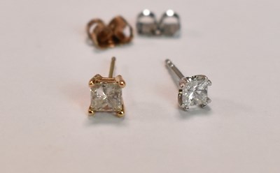 Lot 431 - Two single diamond ear studs, both princess...