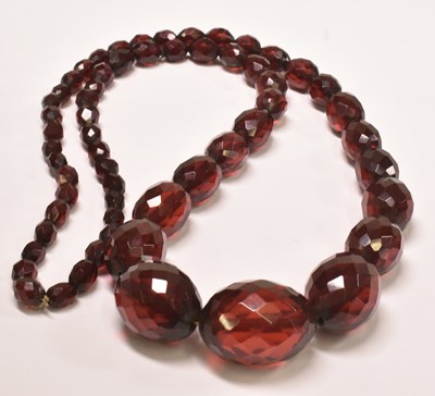 Lot 421 - A vintage cherry amber style graduated facet...