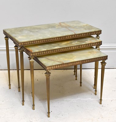 Lot 1061 - A nest of three onyx and brass tables, largest...
